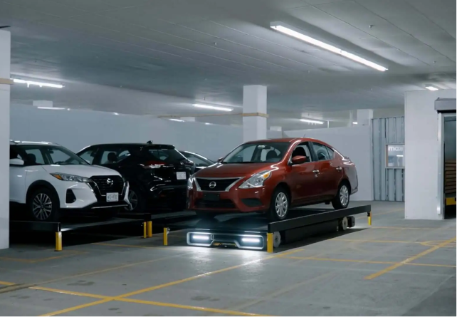 Three cars parked on an automated parking platform inside a garage.
